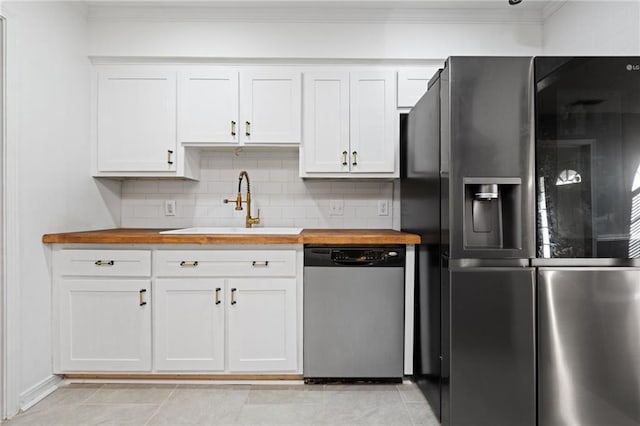 kitchen featuring stainless steel appliances, backsplash, ornamental molding, a sink, and wood counters