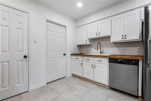 kitchen featuring decorative backsplash, white cabinets, butcher block counters, appliances with stainless steel finishes, and a sink