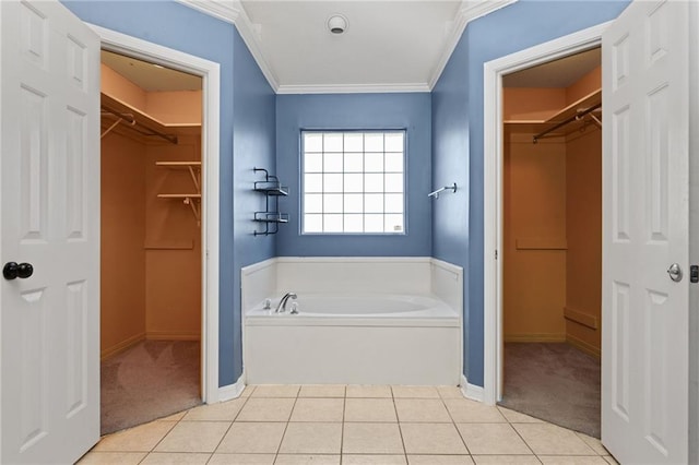 full bath featuring baseboards, tile patterned floors, a garden tub, a spacious closet, and crown molding