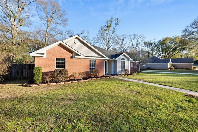 ranch-style home featuring brick siding, a front yard, and fence