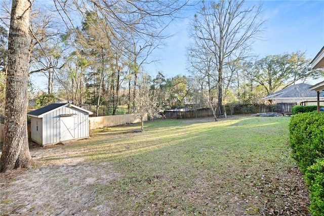 view of yard with an outbuilding, a storage unit, and a fenced backyard