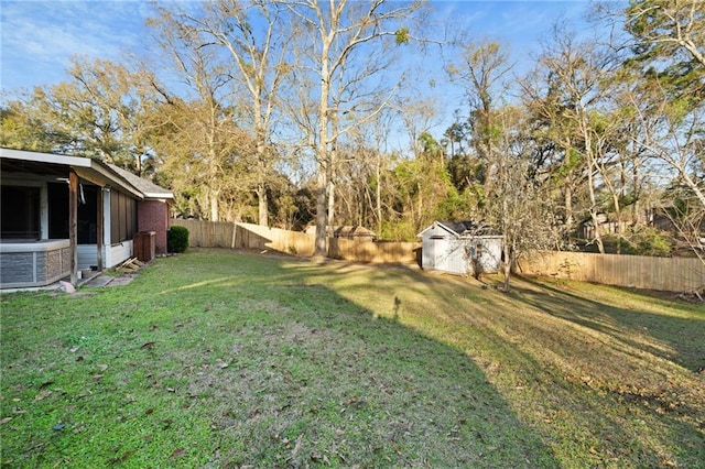 view of yard featuring a fenced backyard, a storage unit, and an outbuilding