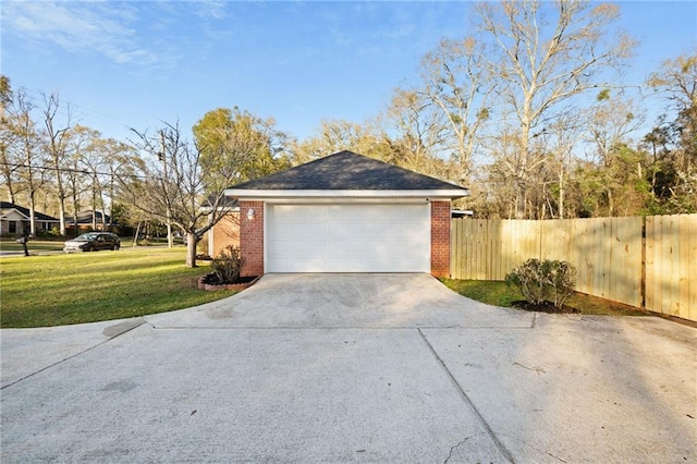 garage featuring fence and driveway