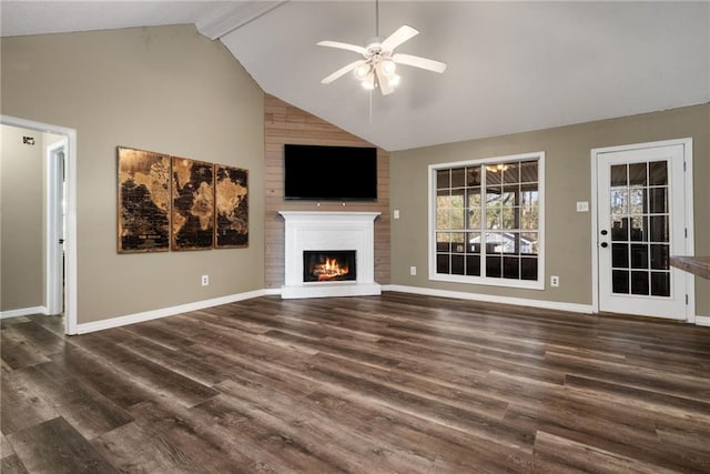 unfurnished living room featuring ceiling fan, dark wood-type flooring, a fireplace, baseboards, and beamed ceiling