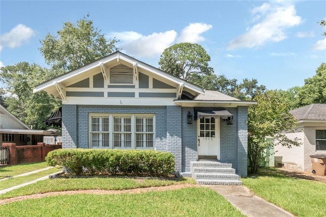 bungalow-style home with a front yard