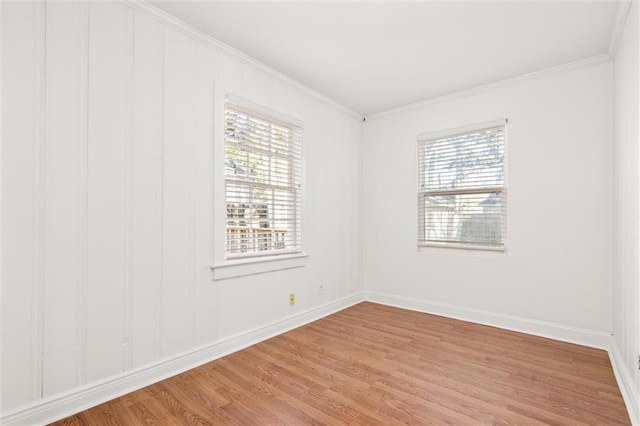 empty room with a healthy amount of sunlight, light hardwood / wood-style flooring, and ornamental molding