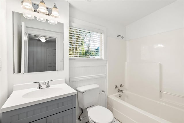 full bathroom featuring ceiling fan, toilet, vanity, and bathing tub / shower combination