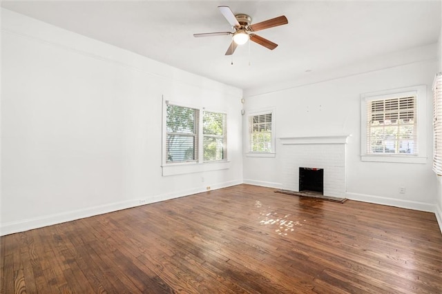 unfurnished living room with a fireplace, ceiling fan, and dark wood-type flooring