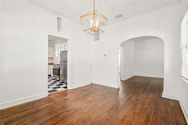 unfurnished room with dark hardwood / wood-style floors and an inviting chandelier