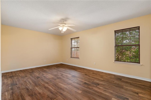 spare room with dark hardwood / wood-style flooring and ceiling fan