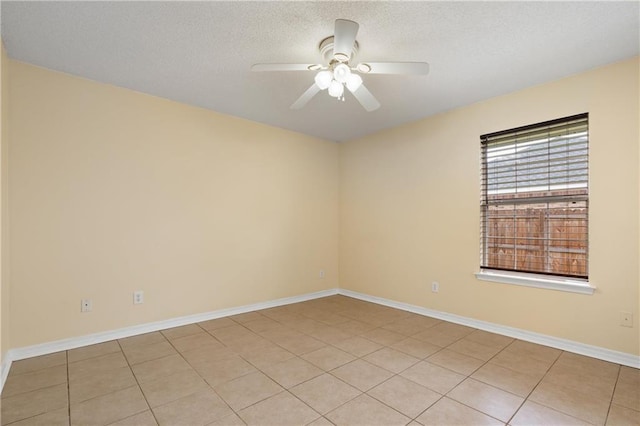 empty room featuring light tile patterned floors, a textured ceiling, and ceiling fan