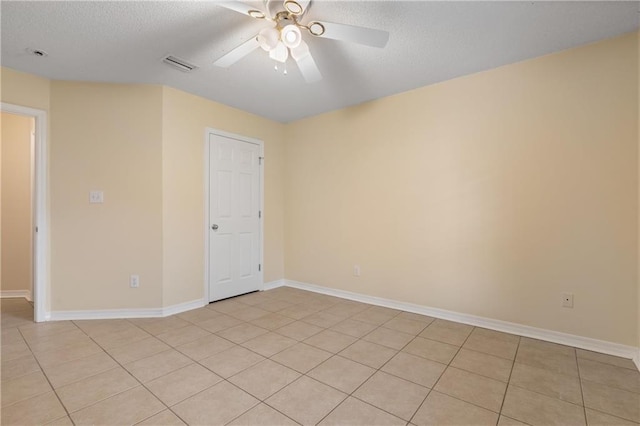 empty room with light tile patterned floors, a textured ceiling, and ceiling fan