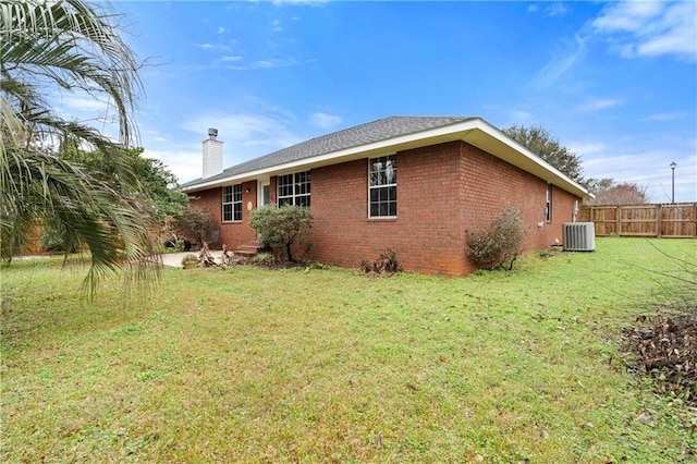 exterior space featuring cooling unit and a lawn