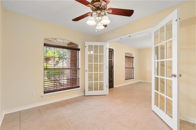 tiled spare room with ceiling fan and french doors