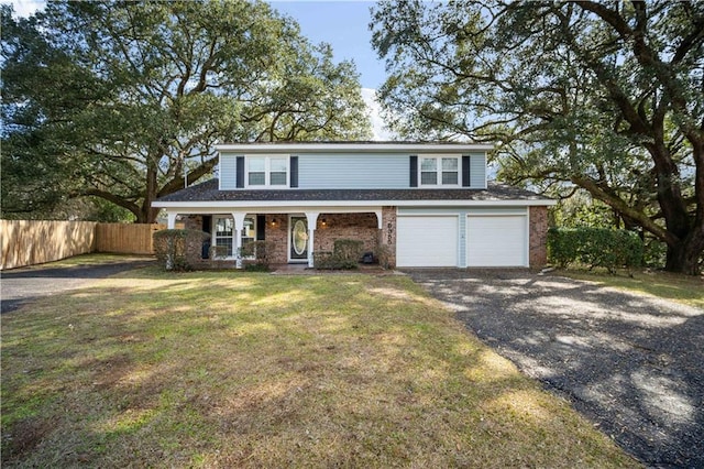 traditional home featuring a porch, aphalt driveway, an attached garage, fence, and a front lawn