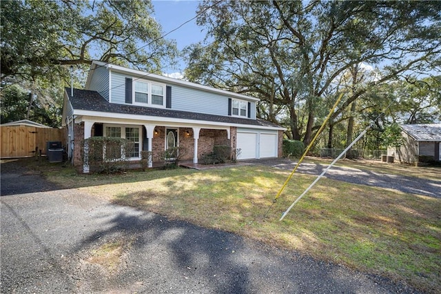 traditional-style home with brick siding, a porch, central AC, fence, and driveway