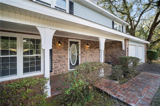 property entrance with a garage and brick siding