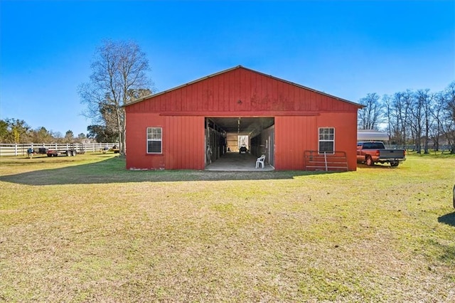 view of pole building with a yard and fence