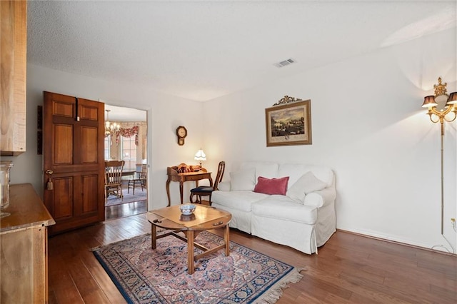 living room with a notable chandelier and dark hardwood / wood-style floors