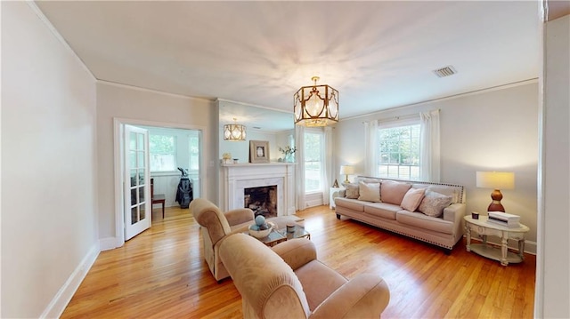 167 Glenwood St, Mobile, AL 36606 - living room with crown molding, a chandelier, light wood-type flooring, baseboards, and a fireplace