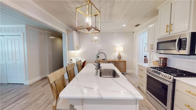 167 Glenwood St, Mobile, AL 36606 - kitchen featuring stainless steel appliances, a sink, crown molding, light wood-style flooring, and backsplash