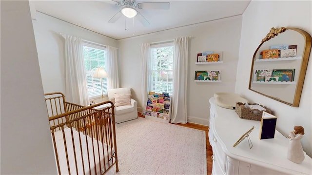 167 Glenwood St, Mobile, AL 36606 - bedroom featuring a crib, wood finished floors, baseboards, and a ceiling fan