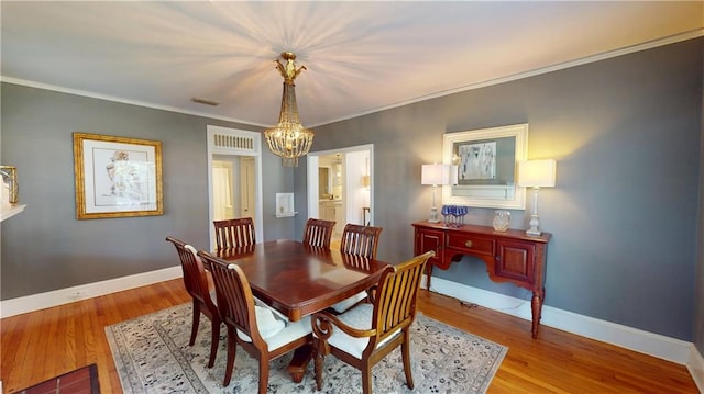 167 Glenwood St, Mobile, AL 36606 - dining room featuring a chandelier, wood finished floors, baseboards, and crown molding