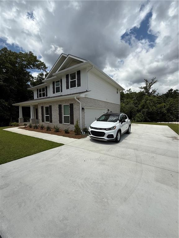 3557 Meadow Ln E, Mobile, AL 36618 - view of front of property featuring driveway, brick siding, a garage, and a front lawn