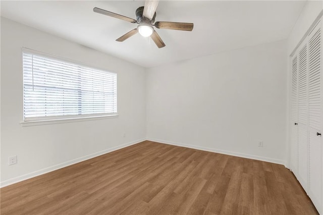 unfurnished room featuring ceiling fan, wood finished floors, and baseboards