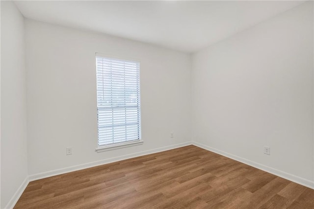 empty room with baseboards and wood finished floors