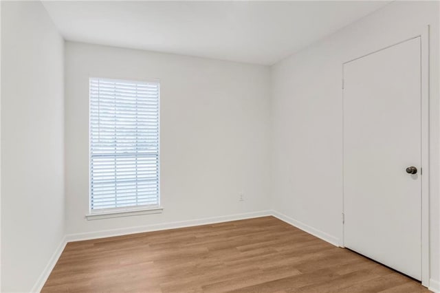 unfurnished room featuring baseboards and wood finished floors