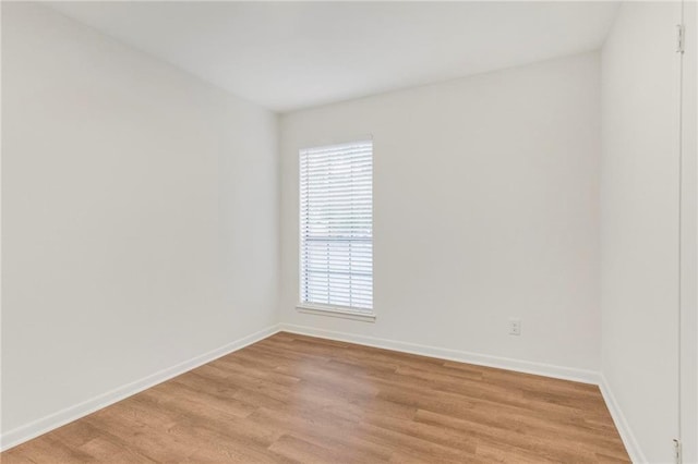 empty room featuring light wood finished floors and baseboards
