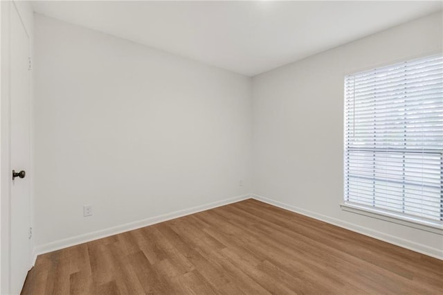 empty room with baseboards and wood finished floors