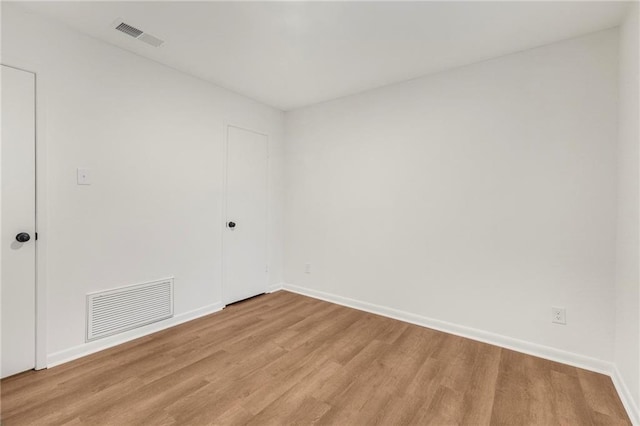 spare room featuring visible vents, baseboards, and light wood-type flooring