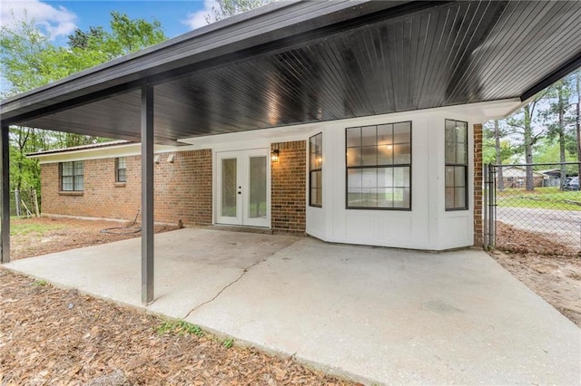 view of patio featuring french doors, fence, and an attached carport