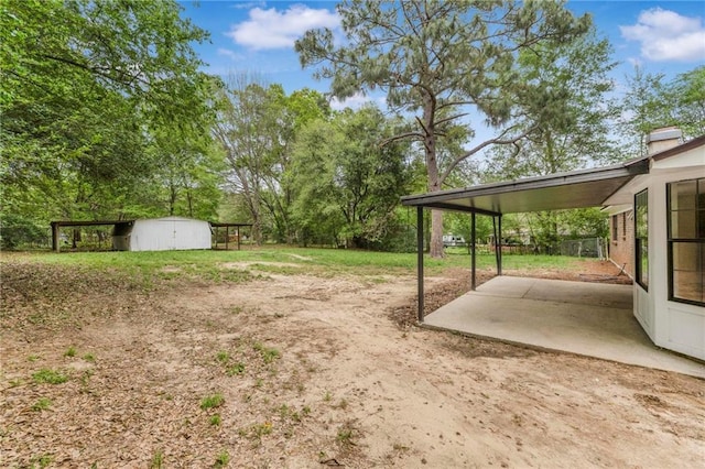 view of yard with an outbuilding, a patio area, and a shed