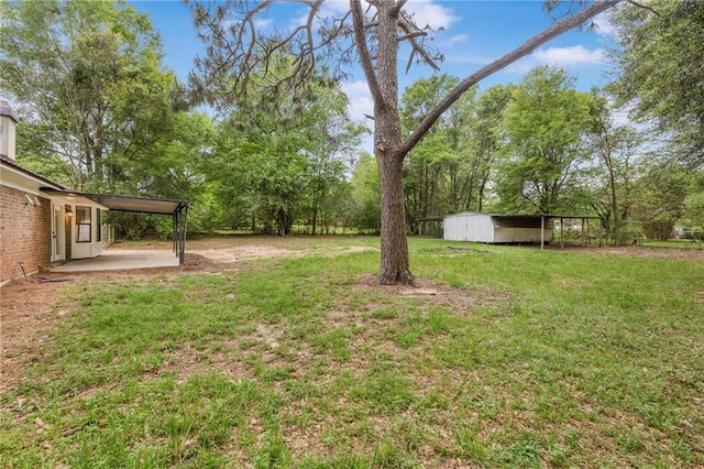 view of yard featuring a patio, an outbuilding, and a carport