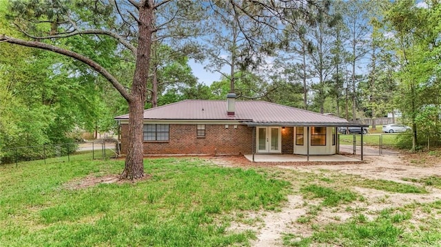 back of house with a yard, a patio, metal roof, fence, and french doors