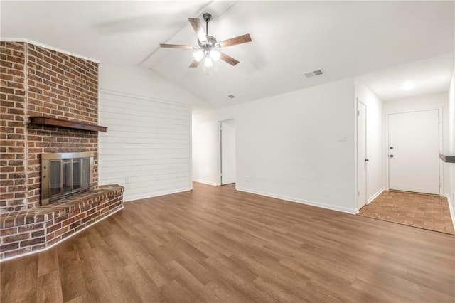 unfurnished living room featuring visible vents, baseboards, a ceiling fan, wood finished floors, and vaulted ceiling with beams
