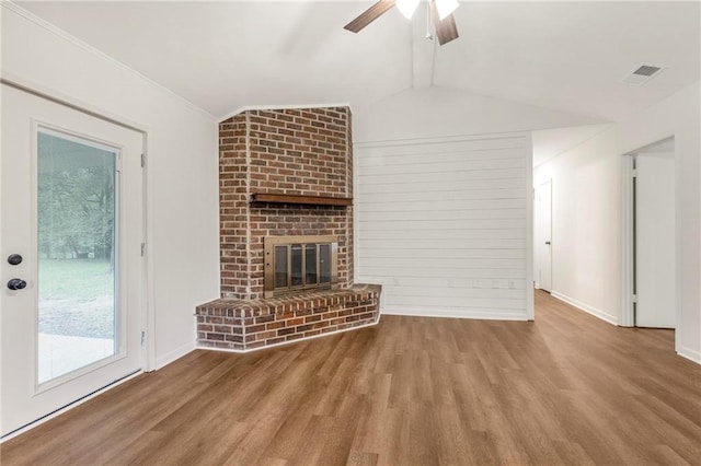 unfurnished living room featuring wood finished floors, ceiling fan, a brick fireplace, and lofted ceiling