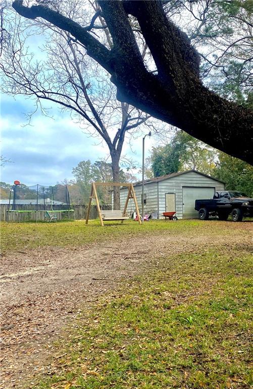 view of yard with an outbuilding and a trampoline