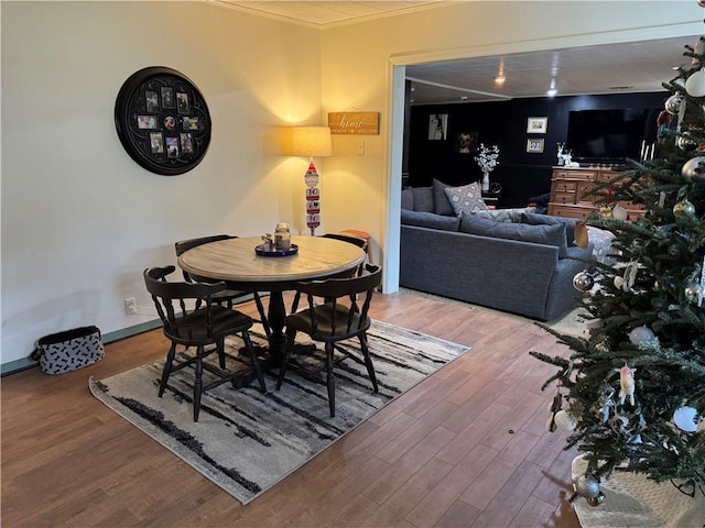 dining area featuring hardwood / wood-style floors and ornamental molding