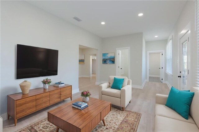 living area featuring light wood-style floors, visible vents, baseboards, and recessed lighting