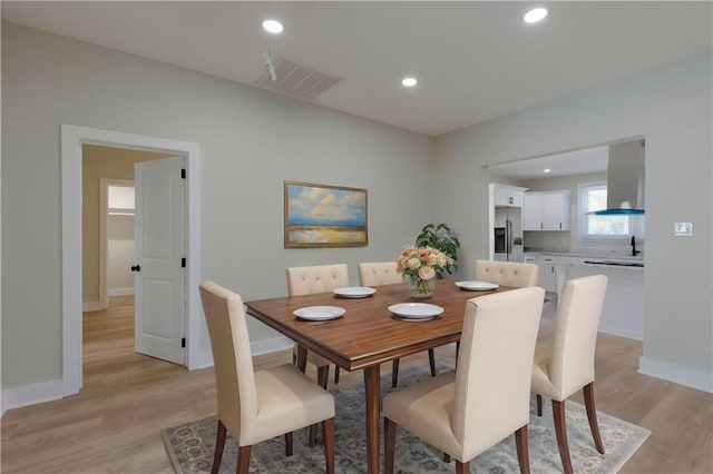 dining area with light wood finished floors, baseboards, visible vents, and recessed lighting