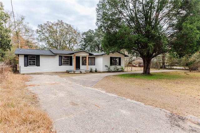 ranch-style home featuring aphalt driveway