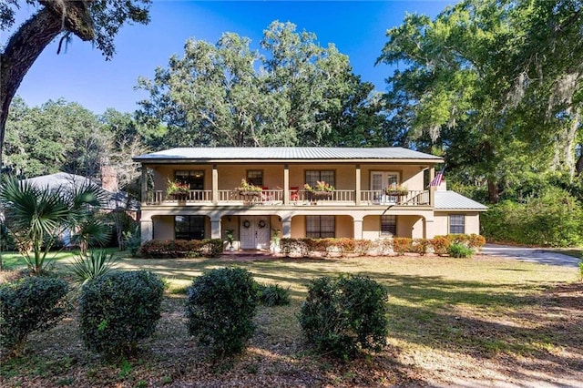 view of front of property featuring a balcony and a front lawn