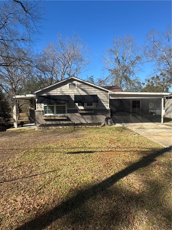 exterior space featuring a carport, a front yard, and concrete driveway