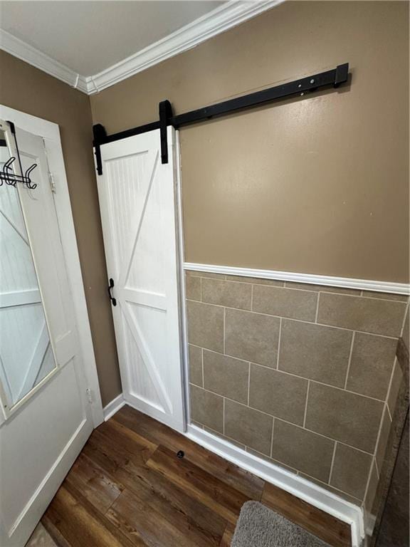 interior space with crown molding, wood finished floors, and a barn door