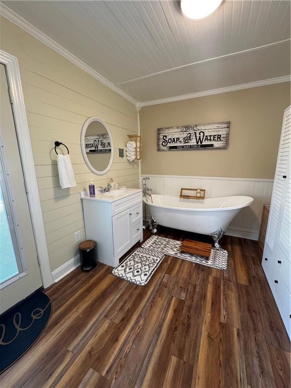 bathroom featuring ornamental molding, a freestanding bath, vanity, and wood finished floors