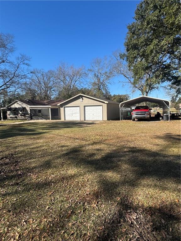 view of property exterior featuring a yard and a detached garage